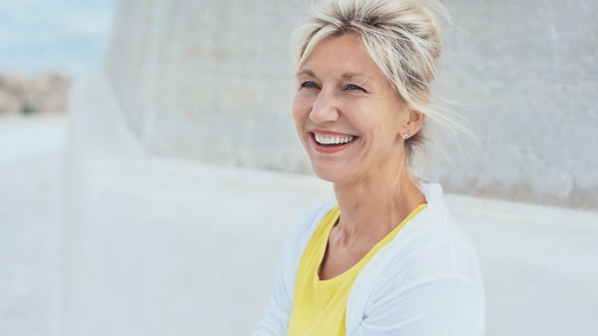 A woman walking a beach with an easy, unhurried sense of energy.